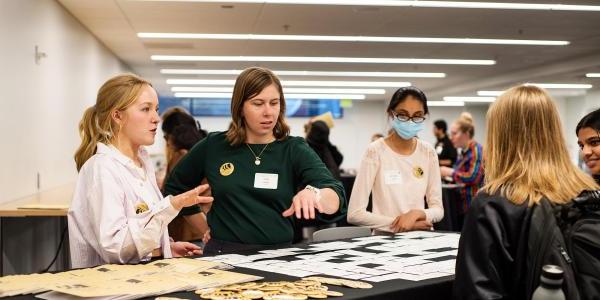 Three staff members work a check-in table for a college event