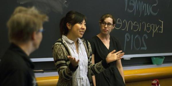 Two academic advisors present to incoming students during a summer orientation event