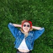 Photo of a girl laying on a bed of lush grass.