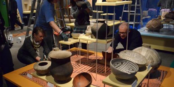 People looking at museum pottery