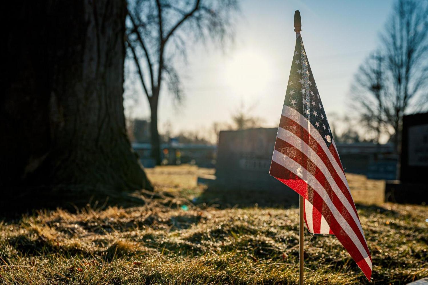 Tiny American flag in ground at cemetery