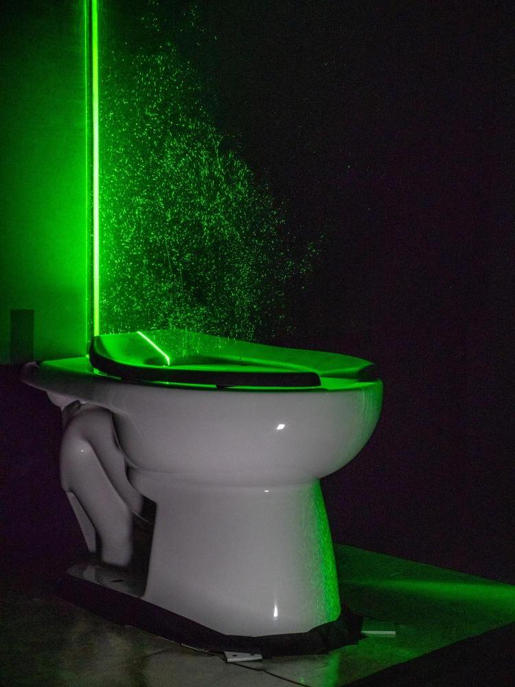 A powerful green laser helps visualize the aerosol plumes from a toilet 