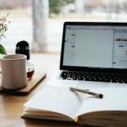 A laptop, cup of coffee and a notebook