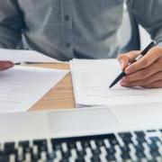 Person doing paperwork at a computer